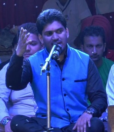 Sunil singing into a microphone on stage