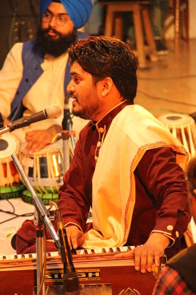 Sunil Sajal performing with harmonium and accompanying musicians